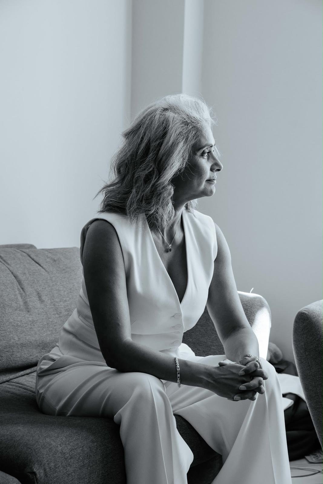 Dimple Amore (Dimple Thakrar), black and white editorial portrait, seated in quiet conversation